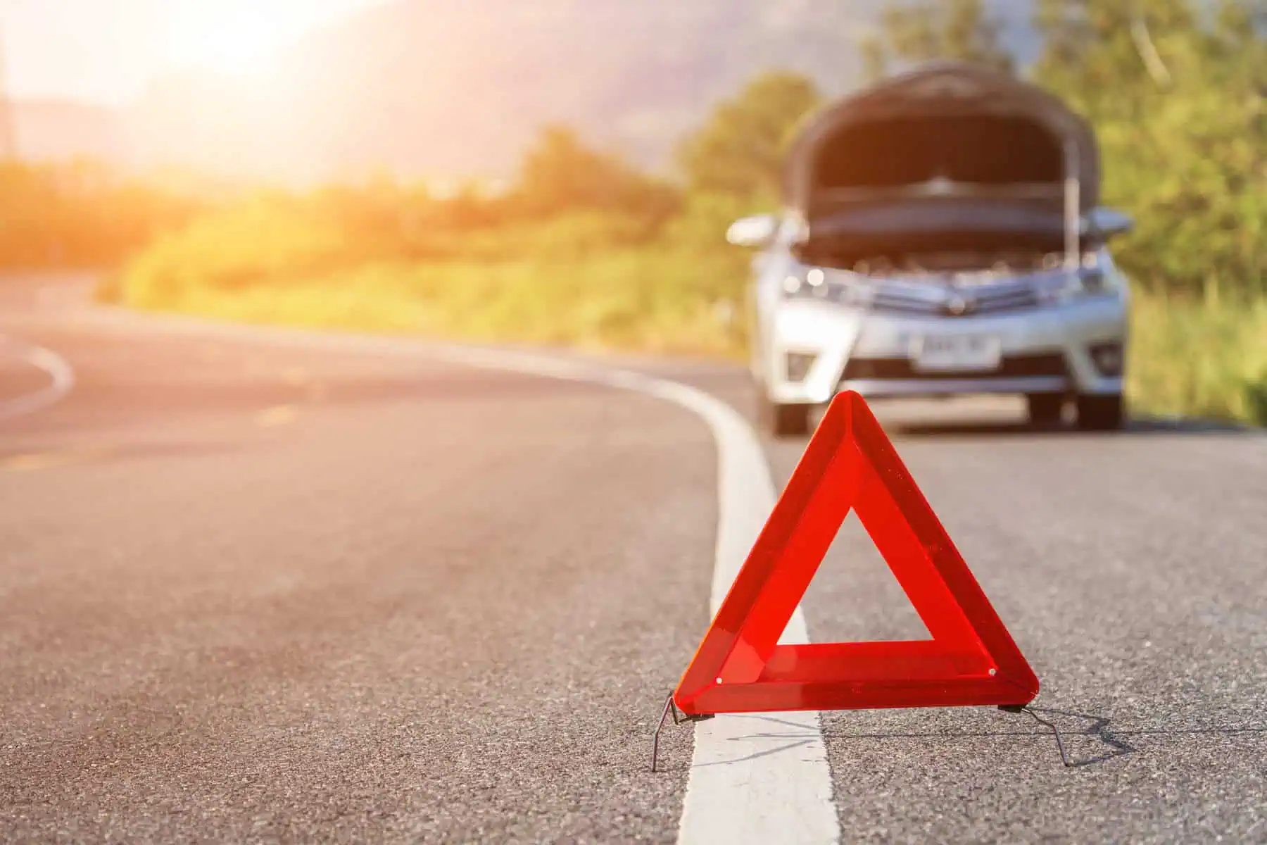 Señal de parada de emergencia roja y auto roto en la carretera Sobrecalentamiento del automóvil, la luz de la temperatura del automóvil se ilumina, olores del automóvil, problemas graves en el automóvil