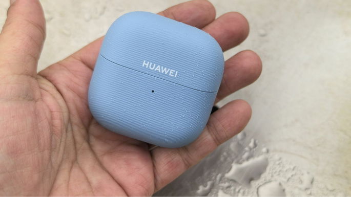 Huawei FreeClip 2 abierto en la mano con fondo de agua