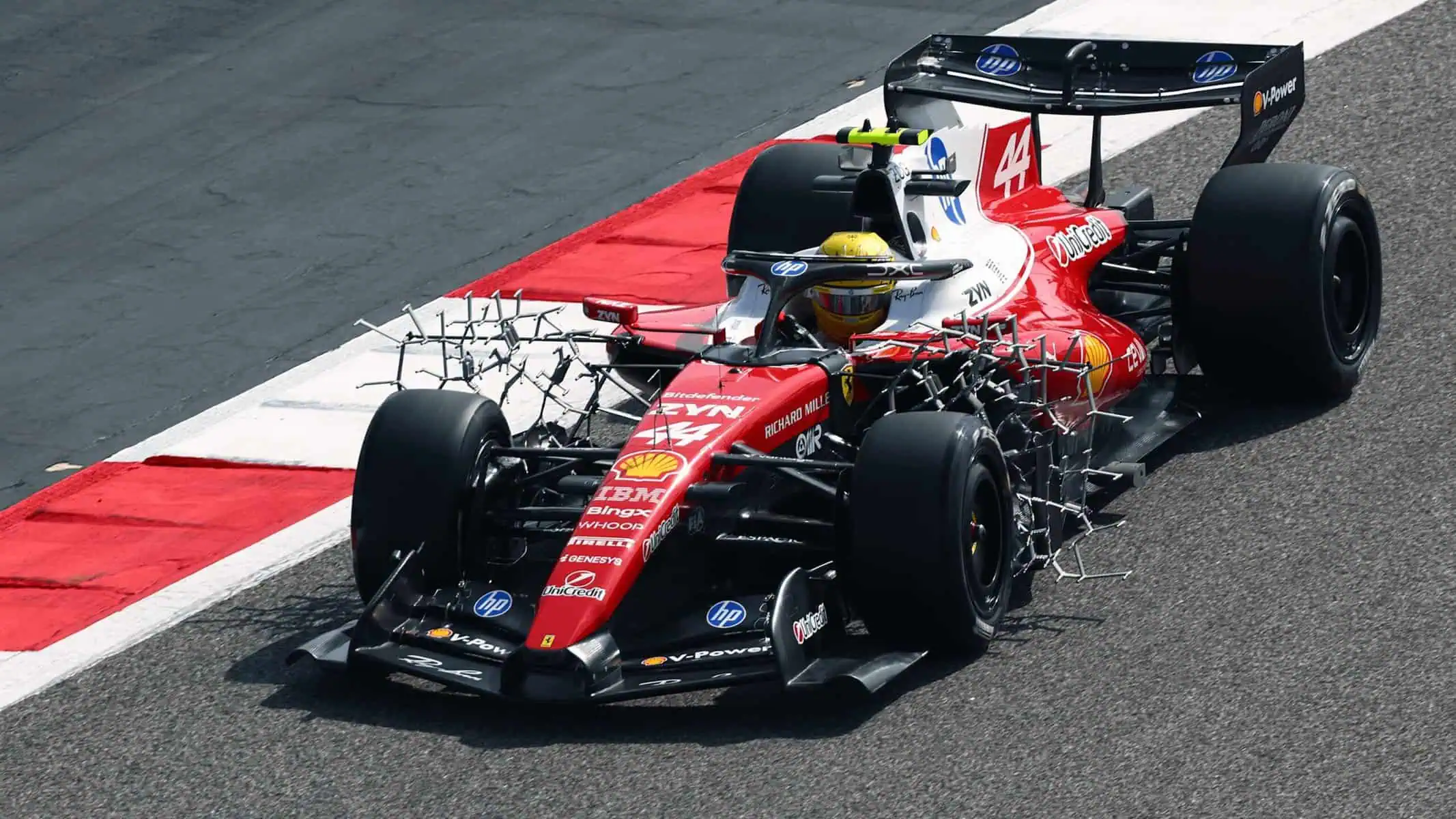 Coche de F1 con extraña pintura verde en la pista de carreras.