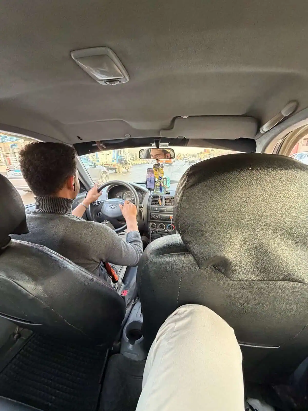 Conducir un coche en la ciudad, vista desde el interior del vehículo con conductor y pasajero, tráfico urbano.