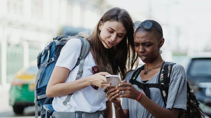 Imagen de dos personas consultando Google Maps en un smartphone