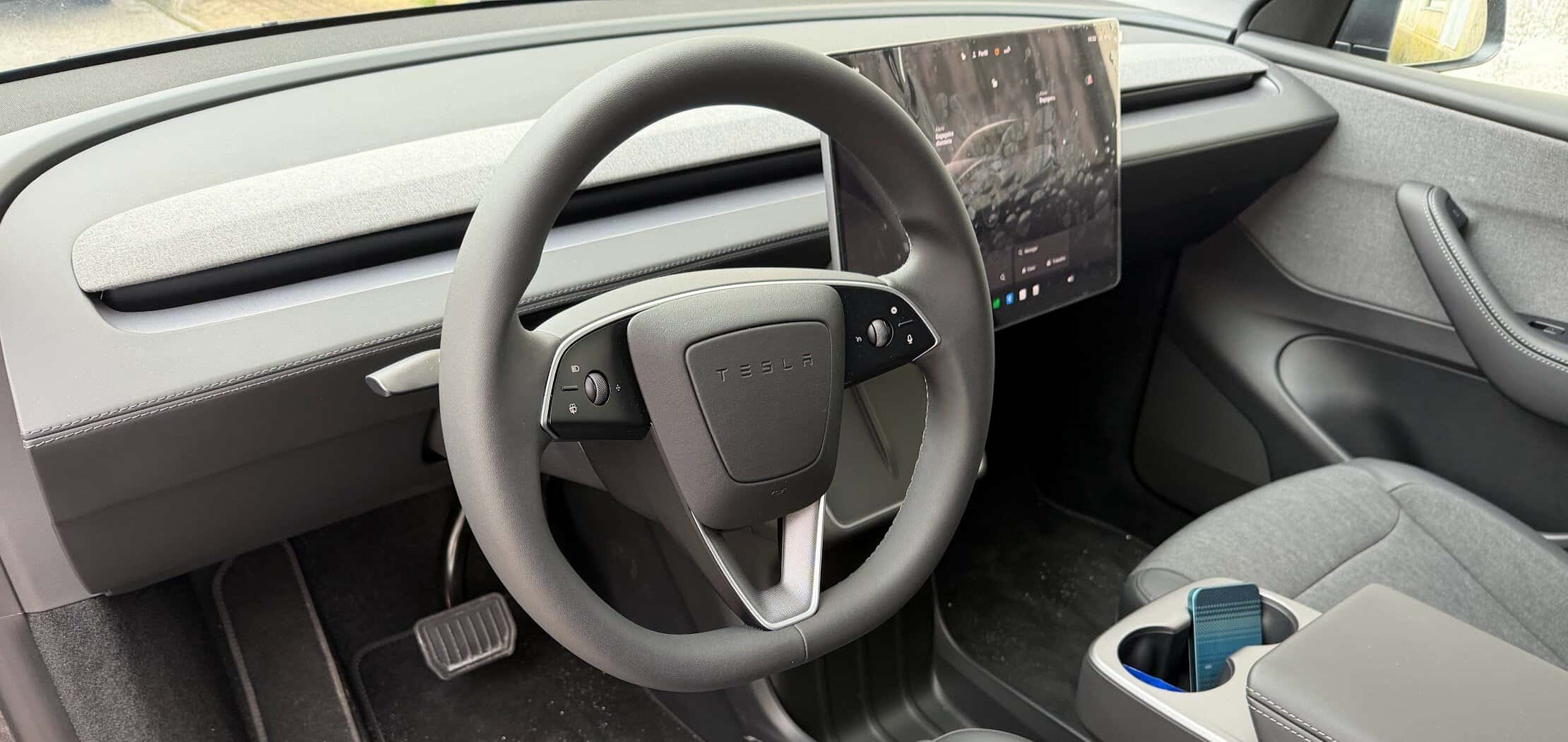 Volante Tesla Model Y con tablero digital e interior moderno.