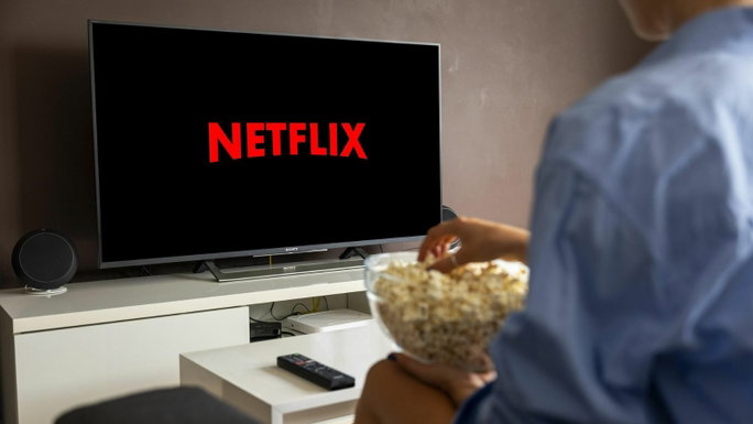 Imagen de una persona mirando televisión y comiendo palomitas de maíz.
