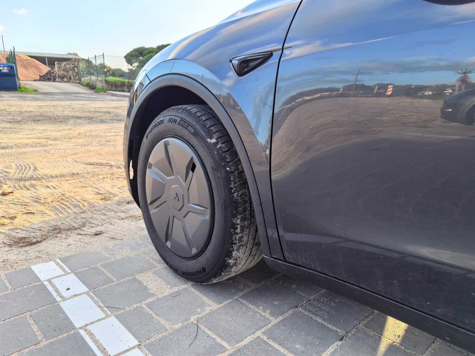 Tesla Model Y Rueda delantera estándar con cubierta aerodinámica, coche eléctrico asequible y eficiente.