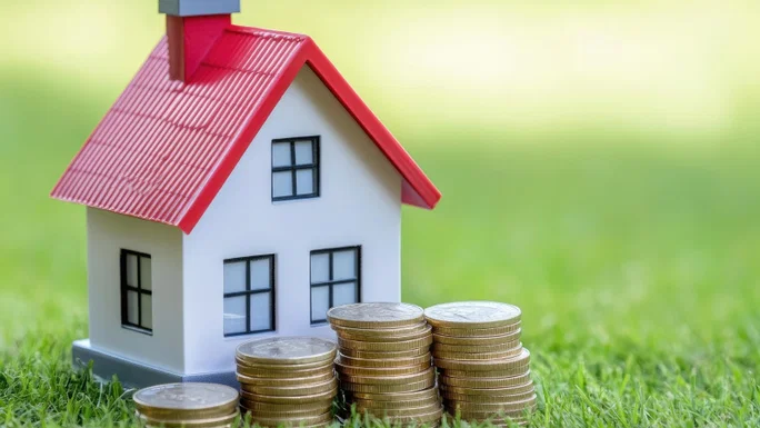 Casa en miniatura con monedas.