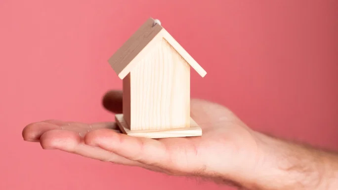 Casa en miniatura en la mano.